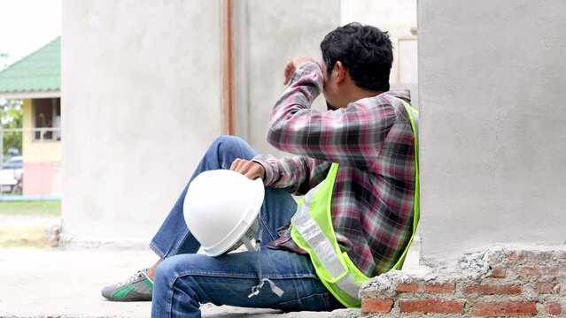 Hopeless middle-aged Indian worker stressed sweat tired sitting on cement floor at construction site worried about financial crisis or termination of employment, oversupply labor in industry business