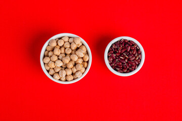 Red kidney beans and chickpeas source of natural protein in white cup on red background