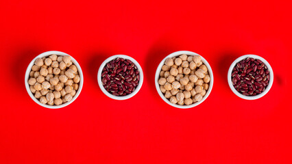 Red kidney beans and chickpeas source of natural protein in white cup on red background
