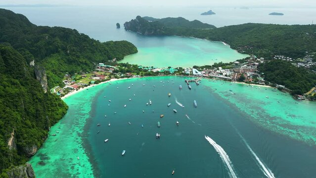 Scenic turquoise water landscape of Kho Phi Phi Island, Boats sailing across the beach water, Aerial Shot