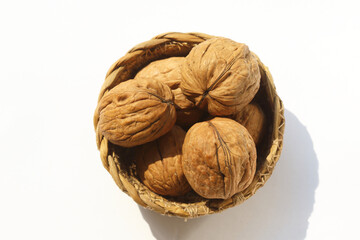 close up of walnuts in the shell on white background
