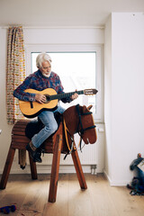 Senior Man Playing Cowboy With Toy Horse