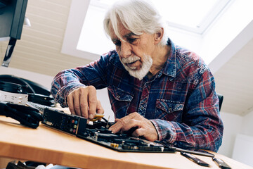 Senior Man Assembling Computer Parts