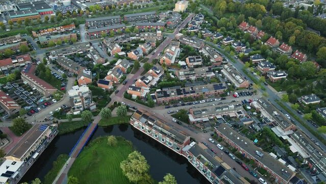 Drone slowly flying over a middle class neighborhood in a small town. Solar panels are on top of most of the homes