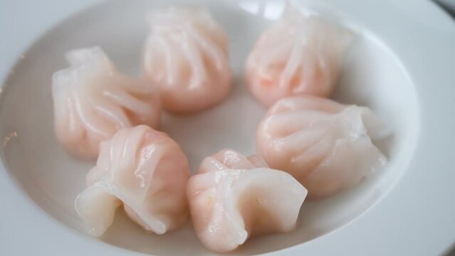 A steamed shrimp dumpling dish is displayed on a table as part of a Cantonese culinary food and dim sum experience.