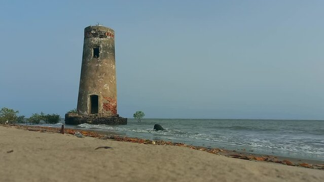 Tower of a small destroyed lighthouse on the beach