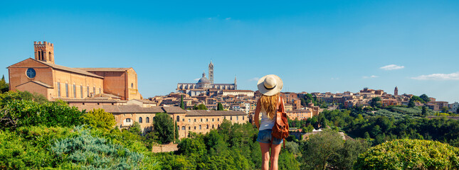 Obraz premium Woman tourist looking at panoramic view of Siena cityscape in Italy- tour tourism,travel,vacation in Europe