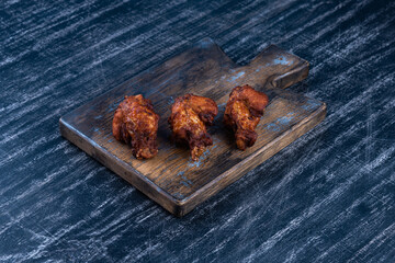 Fried barbecue chicken wings on a wooden tray