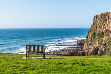 Bench with view of the cliffs on the north Cornish coast near Bude, England