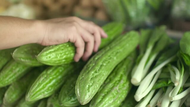 A Customer In Market Checking for Bitter Gourd and Pechay From The Store