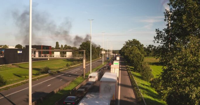 Black smokes rise from car accident in Belgium, time lapse view