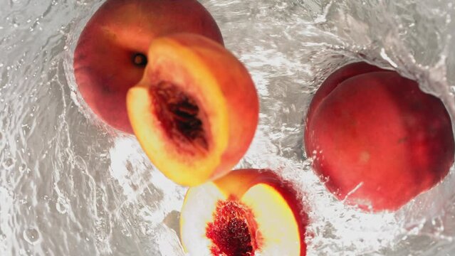 Super Slow Motion Shot of Fresh Peaches Falling into Water Whirl