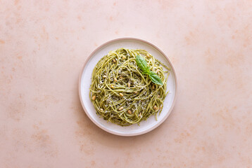 Fototapeta na wymiar Spaghetti pasta with pesto, basil and Parmesan cheese. Italian cuisine. Vegetarian food.