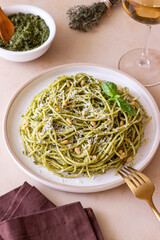 Spaghetti pasta with pesto, basil and Parmesan cheese. Italian cuisine. Vegetarian food.