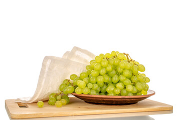 Sweet organic grapes with clay plate on bamboo kitchen board, macro isolated on white background.