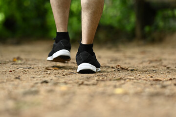 Young fitness man trail runner legs running in the forest. Sports, adventure and healthy lifestyle