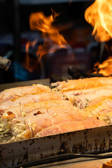 Grilling barbecue meatloaf rolled with vegetables at traditional night market in South Korea.