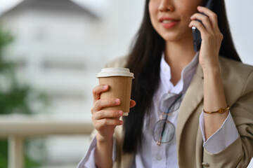 Businesswoman talking on mobile phone while standing outside office building office