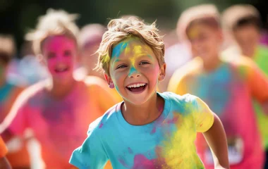 Fototapeten Smiling kids covered in colour during a colour run. © OPPERMAN
