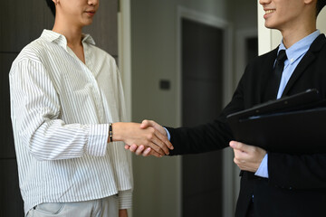 Real estate broker shaking hands with client after buying selling property. Real estate mortgage and property investment concept