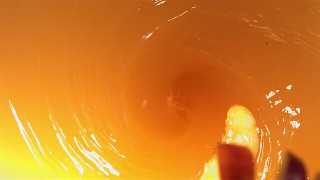 Super Slow Motion Shot of Fresh Peaches Falling into Juice Whirl