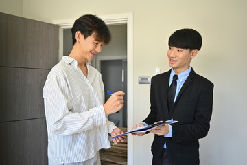 Happy asian man signing contract after consulting with real estate agent. Real estate and and loan ownership concept