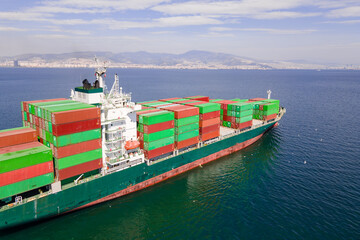 Fully loaded container ship cruising sea to port for logistics import export, maritime shipping or...