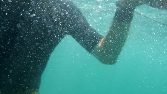 Slow-motion underwater recording: panicked diver amidst swirling air bubbles.