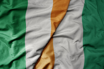 Fototapeta premium big waving national colorful flag of ireland and national flag of cote divoire .