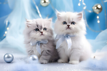 Two adorable white kittens with ribbon bow in Christmas holiday decoration setting with baubles and sparkles.