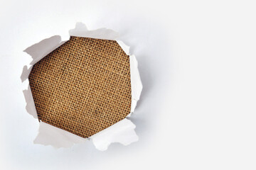 Big paper hole in the middle of burlap background. Blank space to insert your advertising content promotion or text information. Concept for your advertising promotion.