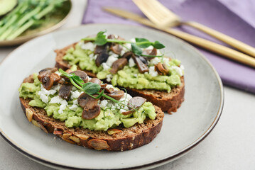 Avocado toast  with mushrooms, feta cheese and microgreens