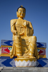 gilded buddha statue on blue sky background