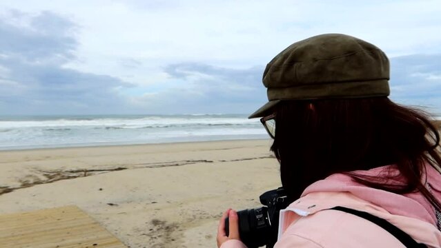 Woman photographer at the beach covering the camera lens. Aveiro, Portugal