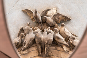 Sculpture monument to city pigeons on the house.
