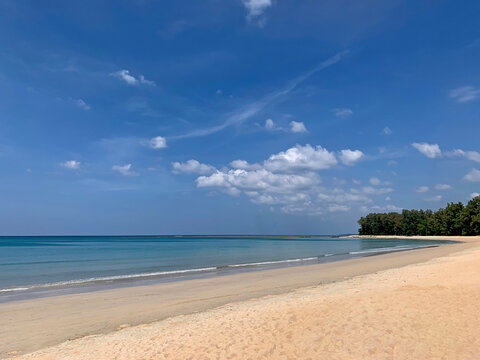 Peaceful famous Nai Yang beach in Phuket island. View of beautiful blue calm Andaman sea, tropical seashore with soft sand, blue sky. Nature landscape view in Thailand.