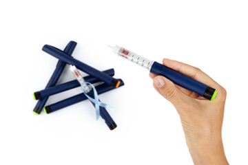 World Diabetes Day, in a woman's hand there is a syringe pen with a needle for insulin injection, top view