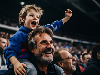 French father and son in stands, filled with enthusiastic supporters of rugby or football team wearing blue clothes to support national sports team