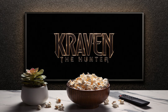 Kraven the Hunter trailer or movie on TV screen. TV with remote control, popcorn bowl and home plant. Astana, Kazakhstan - September 8, 2023.