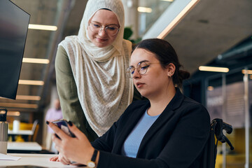 In a vibrant and diverse modern startup, a group of contemporary businesswomen, including one wearing a hijab, come together, exemplifying empowerment, diversity, and innovation in the entrepreneurial