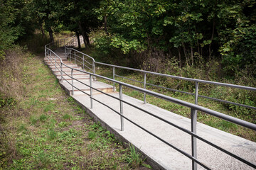 Picturesque staircase with iron railings in the city park. Image for your creative design or illustrations about nature and leisure.