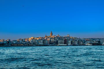 Galata tower and sea and ship in the sunset, Istanbul, Turkey