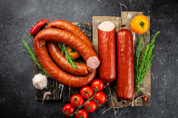Set of smoked sausage, salami on a dark background, banner, menu, recipe place for text, top view