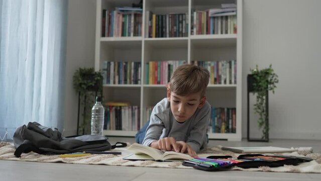 caucasian boy pupil student read book at home study learn slow motion