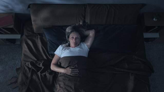 insomnia problem depression,top down view of woman on bed having trouble sleeping,sleepless overthinking female has difficulties to sleep at night overhead shot