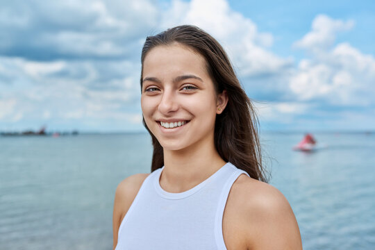 Portrait of smiling teenage girl outdoor on sea background