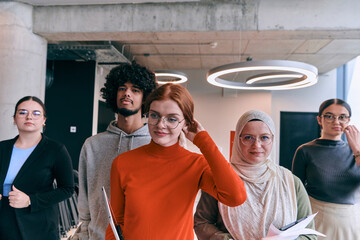 Obraz premium In the sleek corridors of a modern startup office, a diverse group of colleagues, led by their director, confidently stride forward, symbolizing collective success and the journey toward new business