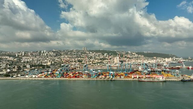 Haifa commercial port dock with Container ship, stacked shipping containers and cranes