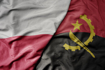 big waving national colorful flag of poland and national flag of angola .
