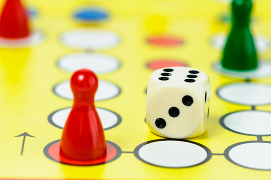 Pieces and a die on a Ludo board game